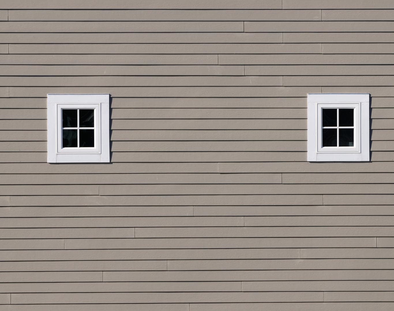 Lap siding wall with white-trimmed windows