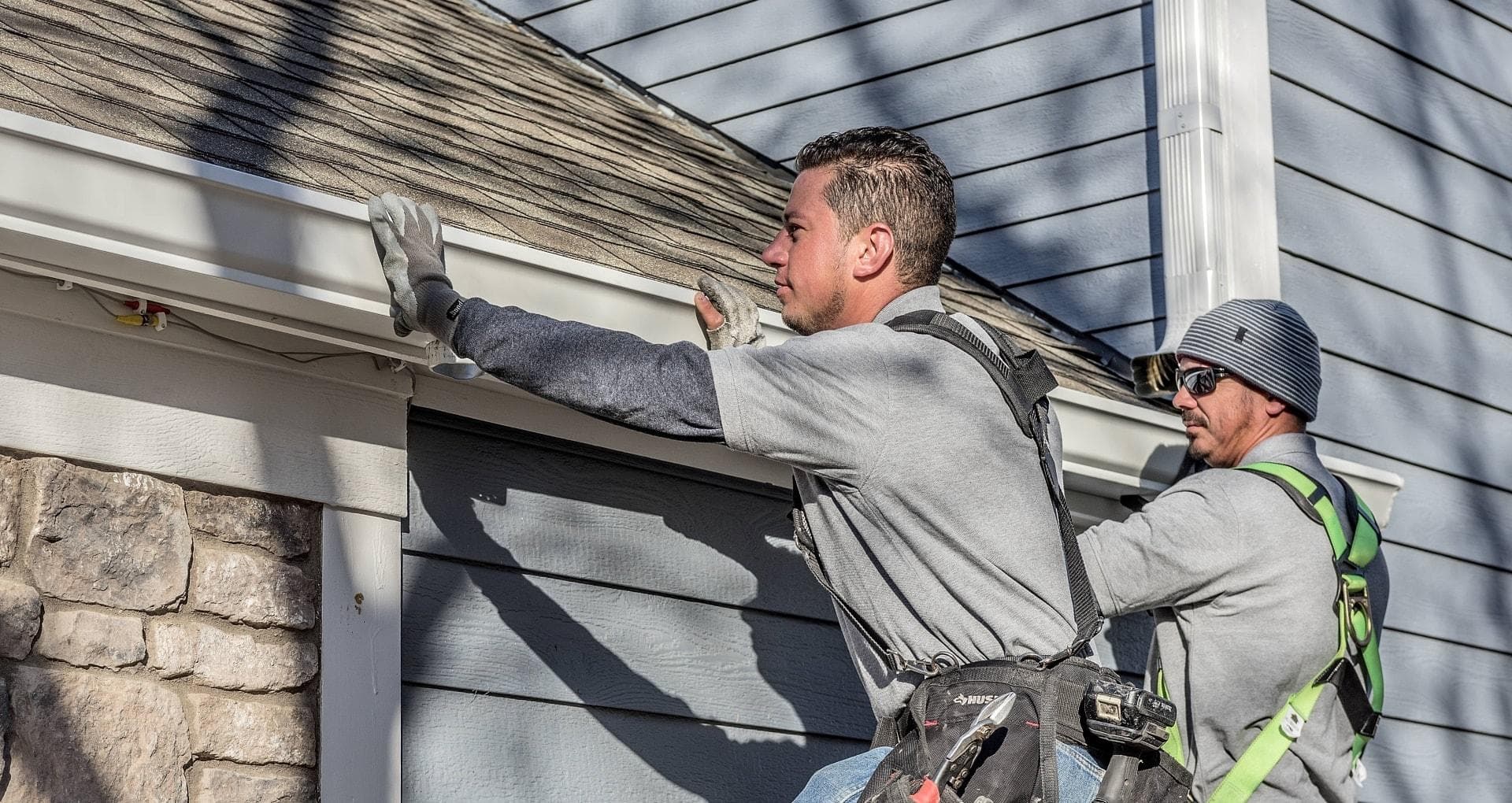 Crew installing seamless aluminum gutters on an Omaha, NE home